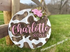 a sign that says charlotte rose on it in front of a wooden fence with flowers