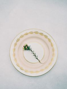 an empty plate with a single flower on it