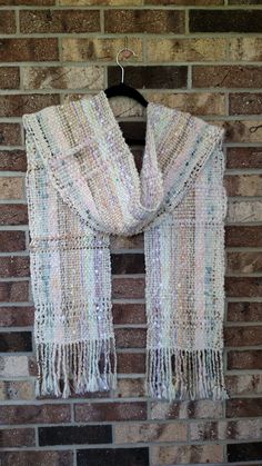 a white scarf hanging on a brick wall