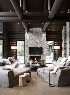 a living room filled with furniture and a fire place in the middle of a room