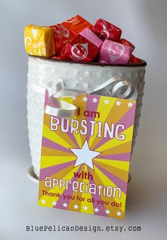 a bucket filled with lots of different colored candies next to a sign that says i am bursting with appreciation