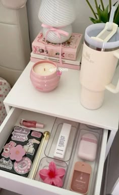 a white table topped with lots of items and a pink cup on top of it