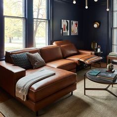 a living room filled with furniture and large windows