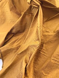 an image of a yellow cloth that is very soft and drapy with some stains on it