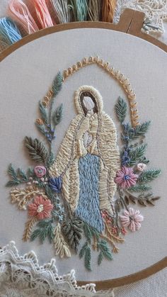 an embroidery project with a woman holding a baby in her arms