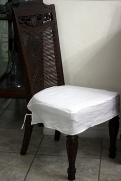 a wooden chair with a white cover on it