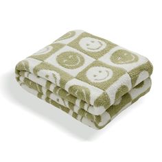 two towels stacked on top of each other in front of a white background with green and white squares