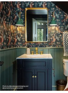 a bathroom with green and gold wallpaper and a white sink under a large mirror