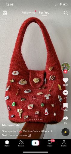 a red purse with lots of different buttons on it's front and back side