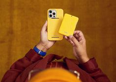 two people holding up their cell phones in front of them, one is yellow and the other is red