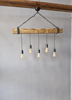 five light bulbs hanging from a wooden beam