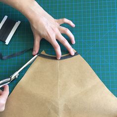 someone cutting out a paper bag with scissors