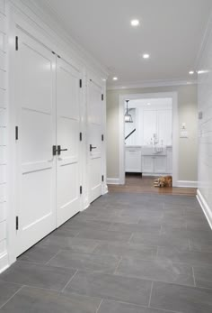 an empty room with white doors and gray flooring