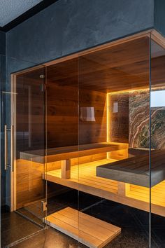 an indoor sauna with glass walls and wooden benches