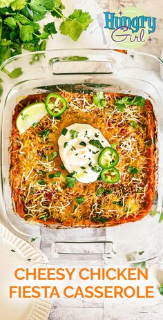 a cheesy chicken fiesta casserole in a glass dish with limes and cilantro