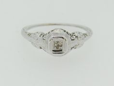 This precious Antique Ring features one single cut diamond in the center. Set in 14K white gold. The size is a 6.25. Total weight is approx. 1.2 grams. (T3 * MJP039519) Please review all photos before purchasing and feel free to ask questions about the item :) We are sorry but we do NOT offer INTERNATIONAL SHIPPING! Payment due upon checkout to avoid shipping delays and loss of purchased item. Payment's not made within 72 hours will result in cancellation of your order unless expressed communica Silver Engraved Ring With Single Diamond, Classic Engraved White Gold Ring With Diamond Accents, White Gold Rectangular Engraved Ring For Anniversary, Elegant White Gold Engraved Rectangular Ring, Heirloom White Gold Single Diamond Ring, Vintage Rectangular Diamond Ring In White Gold, Vintage White Gold Rectangular Diamond Ring, Anniversary White Gold Engraved Ring With Diamond Accents, Engraved White Gold Diamond Promise Ring