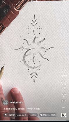 someone is drawing something on paper with a pen and inking it in the shape of a flower