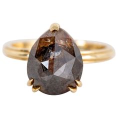 a yellow gold ring with a large brown diamond