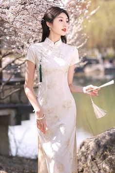 Discover a feminine long white cheongsam dress that is great for modern outfits. With its graceful long length, this cheongsam dress will flatter your body shape and highlight your waist. The charming white color adds a touch of sophistication to the long cheongsam. Elegant White Ao Dai For Formal Occasions, Elegant Ao Dai With Stand Collar For Spring, Fitted Elegant Ao Dai For Spring, Elegant Fitted Ao Dai For Summer, Elegant Fitted Ao Dai For Spring, White Fitted Dress With Stand Collar, White Cheongsam With Stand Collar For Wedding, Elegant Long Ao Dai For Summer, Spring Formal Cheongsam With Stand Collar