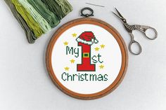 a cross stitch christmas ornament with scissors and thread