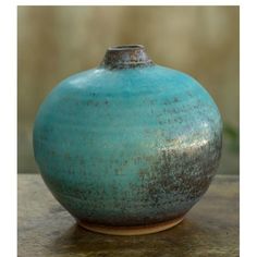 a blue vase sitting on top of a wooden table