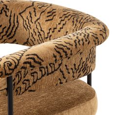 an animal print upholstered chair with black metal legs and arm rests on a white background