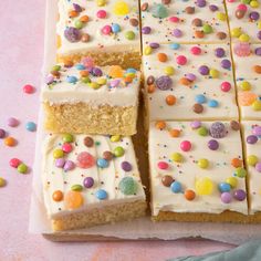 a cake with white frosting and colorful sprinkles on it's side