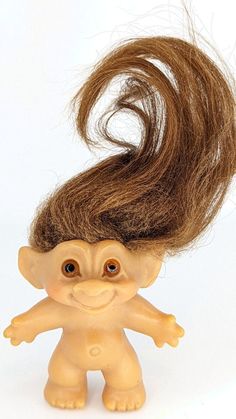 a troll doll with long brown hair on it's head