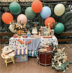 a table topped with lots of cake and balloons