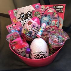 a pink basket filled with lots of toys and items for kids to play with in it