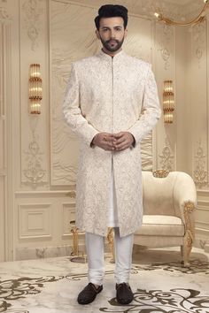 Introducing our Mens Sherwani R14-S66, a luxurious and sophisticated choice for grooms. Adorned with intricate zardozi embroidery, this sherwani exudes elegance and exclusivity. Make a statement on your special day with this magnificent piece. Off White Naqshi Bandhgala, Cream Nehru Jacket With Chikankari Embroidery For Reception, Cream Nehru Jacket For Eid Reception, Off White Sherwani With Chikankari Embroidery For Reception, Off White Sherwani With Chikankari Embroidery For Formal Occasions, Off-white Dabka Sherwani For Transitional Seasons, Elegant Traditional Wear With Naqshi, Elegant Traditional Wear With Naqshi Drape, Elegant Traditional Wear With Naqshi In Traditional Drape