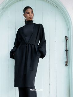 This enveloping Ona Cardigan from Nigerian label Andrea Iyamah is just as soft as it looks. Knitted from an insulating wool blend, it has a flattering longline profile cinched by a matching sash belt at the waist and generous bishop sleeves that add volume. We like it styled with tailored pants and statement heels. Style yours with the label's matching Onyx Ally Knit Pants.- Three-quarter length, narrow placket- Wool blend- Ships from the United States Chic Long Cashmere Cardigan, Chic Long Cashmere Outerwear, Chic Long Cashmere Sweater Coat, Elegant Cashmere Sweater Coat For Daywear, Chic Cashmere Sweater Coat For Work, Long Sleeve Outerwear With Tie Waist For Winter, Winter Outerwear With Tie Waist And Long Sleeves, Chic Merino Wool Outerwear For Work, Long Cashmere Sweater Coat For Work