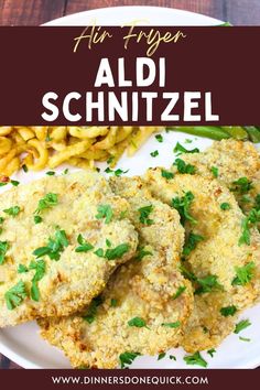 chicken schnitz on a white plate with french fries and parsley garnish