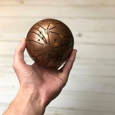 a hand holding an egg with designs on it