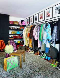 the closet is full of colorful clothes and handbags on display in front of pictures