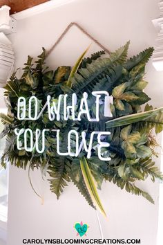 a green wreath with the words, go what you love on it hanging from a wall