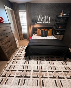 a bedroom with brick walls and black bedding