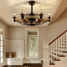 a light fixture hanging from the ceiling in a room with wood floors and white walls