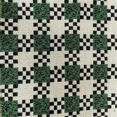 a black and white checkered blanket with green leaves on it