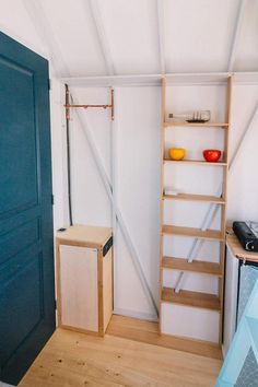 a room with some shelves in it and a blue door on the wall next to it