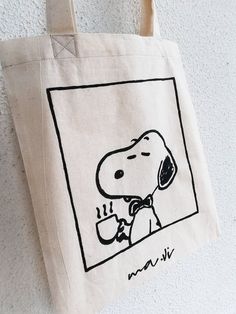 a tote bag with a drawing of a person holding a coffee cup on it