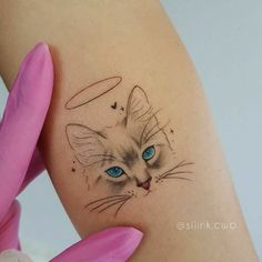 a cat with blue eyes is shown on the thigh and behind her are pink gloves