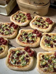 small pizzas with olives and peppers on them