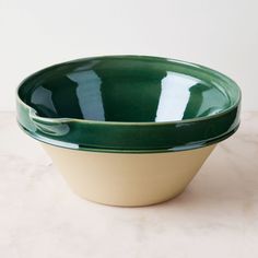 two green and white bowls sitting on top of a table