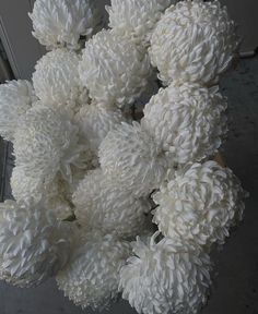 a bunch of white flowers sitting on top of a table next to a window sill