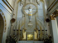 the interior of a church with gold and white decorations on the walls, including a crucifix