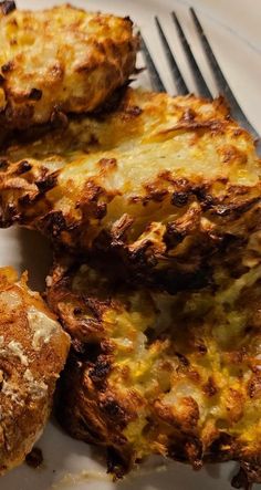 some food is laying on a plate with a fork next to it and another piece of bread