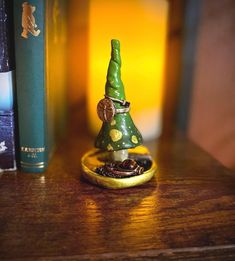 a small green christmas tree sitting on top of a wooden table next to a book