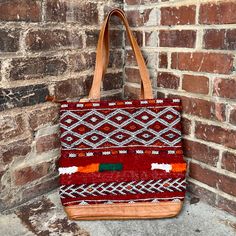 Intertwined's beautifully crafted tote bag is handmade in Morocco from locally tanned leather and vintage, handwoven kilim. Each kilim is one-of-a-kind and handwoven with unique colors and patterns based on the region where it is made. This bag combines style and function! Several of our kilim totes also coordinate with our kilim weekenders so you will truly be traveling in style! Artisan Handwoven Leather Bag, Artisan Handwoven Leather Shoulder Bag, Artisan Leather Handwoven Shoulder Bag, Artisan Bags With Weaving Work For Everyday Use, Travel Tote Shoulder Bag With Weaving Work, Artisan Brown Bag With Weaving Work, Artisan Handwoven Tote Bag, Brown Weaving Work Tote Shoulder Bag, Bohemian Weaving Bags For Shopping