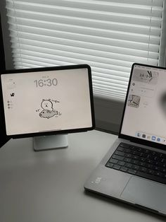 an open laptop computer sitting on top of a desk next to a desktop computer monitor